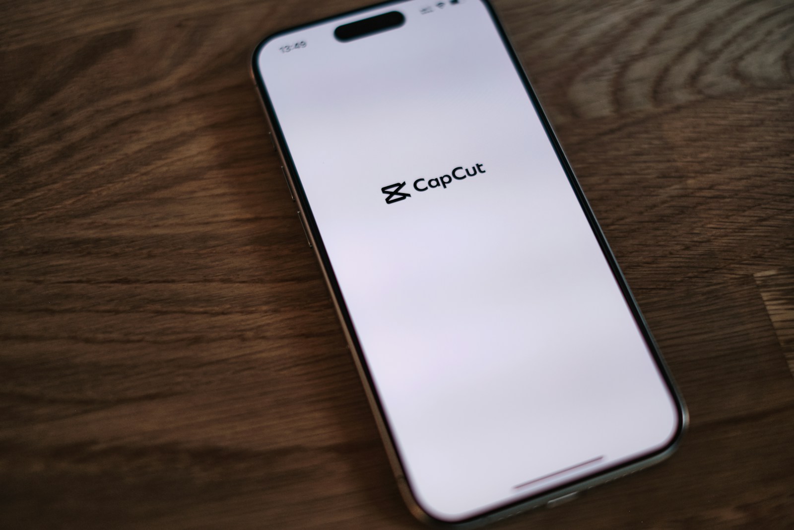 A close up of a cell phone on a wooden table